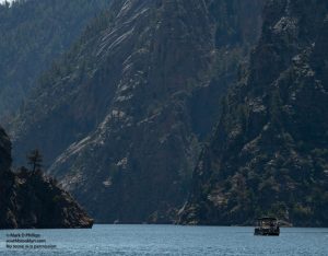 Colorado June 24, 2021: One of two pontoon boats on Morrow Point Reservoir is dwarfed by the beginnings of the Black Canyon of the Gunnison. ©Mark D Phillips