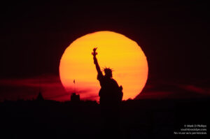Smokey sunset on July 22, 2021, in Gowanus, Brooklyn, silhouettes the Statue of Liberty. ©Mark D Phillips