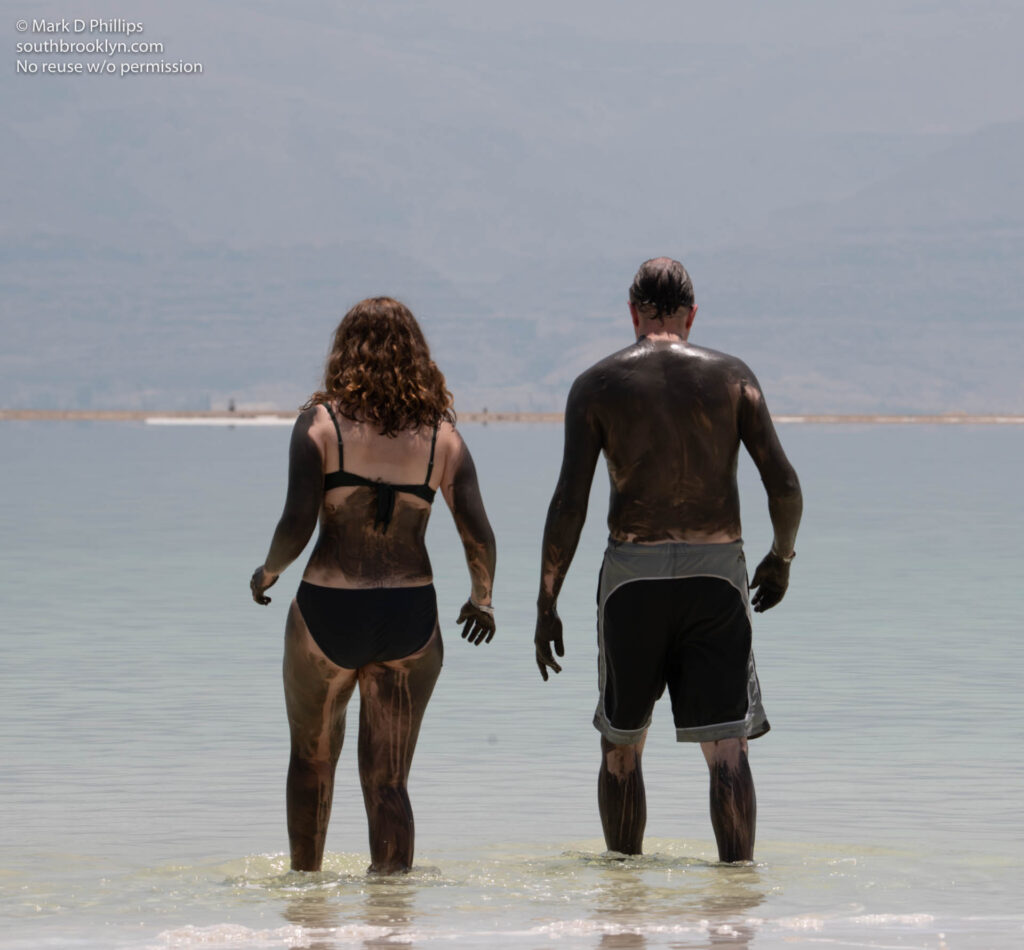 Hannah and Einar Sigurdsson walk out into the Dead Sea covered in its mud at the “new” resorts in Ein Bokek, which are located on the shore of a massive, 30-square mile (80-square-kilometer) evaporation pond. ©Mark D Phillips