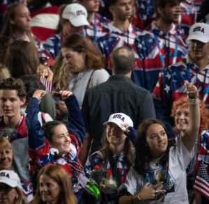 Rachel Katzenberg cheers with a small US flag as she marches into Teddy Stadium for the 21st Maccabiah opening ceremony. ©Mark D Phillips