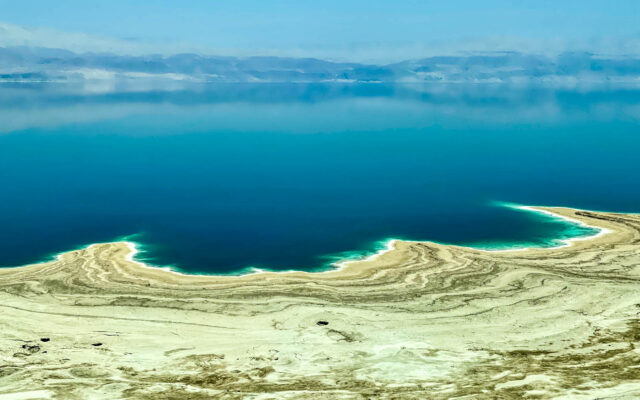 Salt and Green water mark the edges of the shoreline along the Dead Sea near Ein Gedi, Israel, in 2022. ©Mark D Phillips