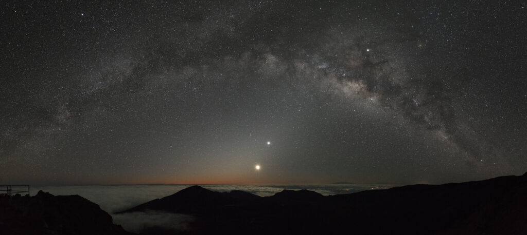 A crescent moon and Venus rise under the Milky Way in this pre-dawn panoramic view from the Kalahaku overlook. One of the several Hawai’ian names for our galaxy is Iʻa-lele-i-aka or “fish jumping in shadows”, an apt description when looking at this image. (Composite of seven individual frames). ©Stan Honda