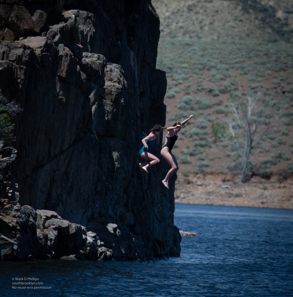 Two young women jump from the cliffs near Elk Creek into Blue Mesa Reservoir on June 21, 2023. ©Mark D Phillips