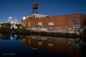 Since 2016, the patch of graffiti on a warehouse by the Carroll Street Bridge on the bank of the Gowanus Canal welcomed visitors with the tagline ‘Welcome to Venice’ with the signature "Love Jerko." But it became a victim of gentrification during the COVID-19 pandemic. The former home of Alex Figliolia Water & Sewer, the 65,000-square-foot industrial building disappeared without a trace. On my first visit to the canal since the pandemic struck, I had one of those "Oh No" moments when I drove across the historic Carroll Street Bridge and realized the graffiti covered wall was gone. Not just gone but obliterated like it had never been there. ©Mark D Phillips